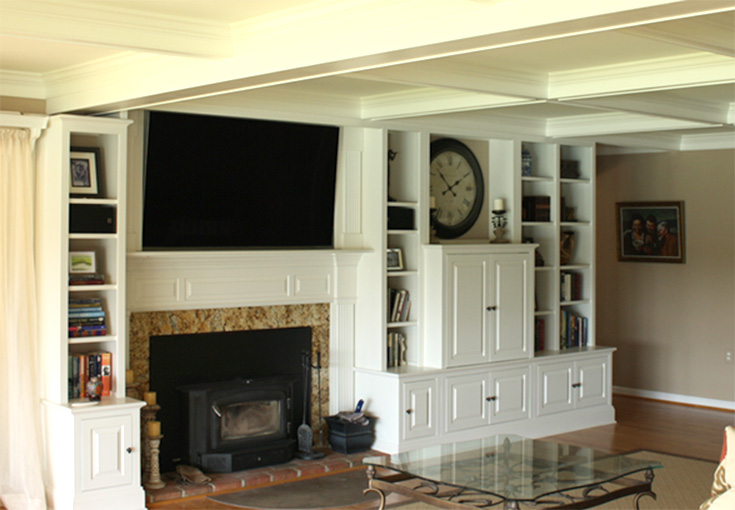 Interior living room with a fireplace, built-in shelving, and a large wall-mounted TV.